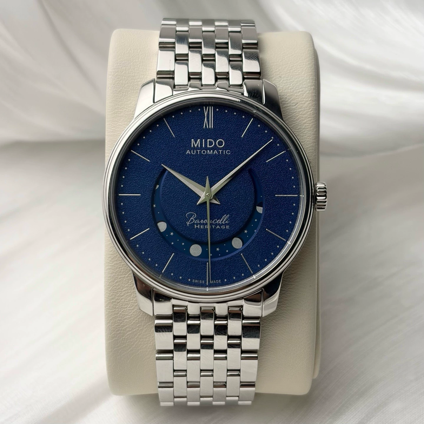 Mido Baroncelli Smiling Moon Gent com mostrador azul sobre almofada clara